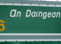 Irish Road sign close up showing outline of the name Dingle under the green tape